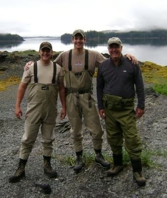 Mark Wood standing beside a lake with two outdoor companions